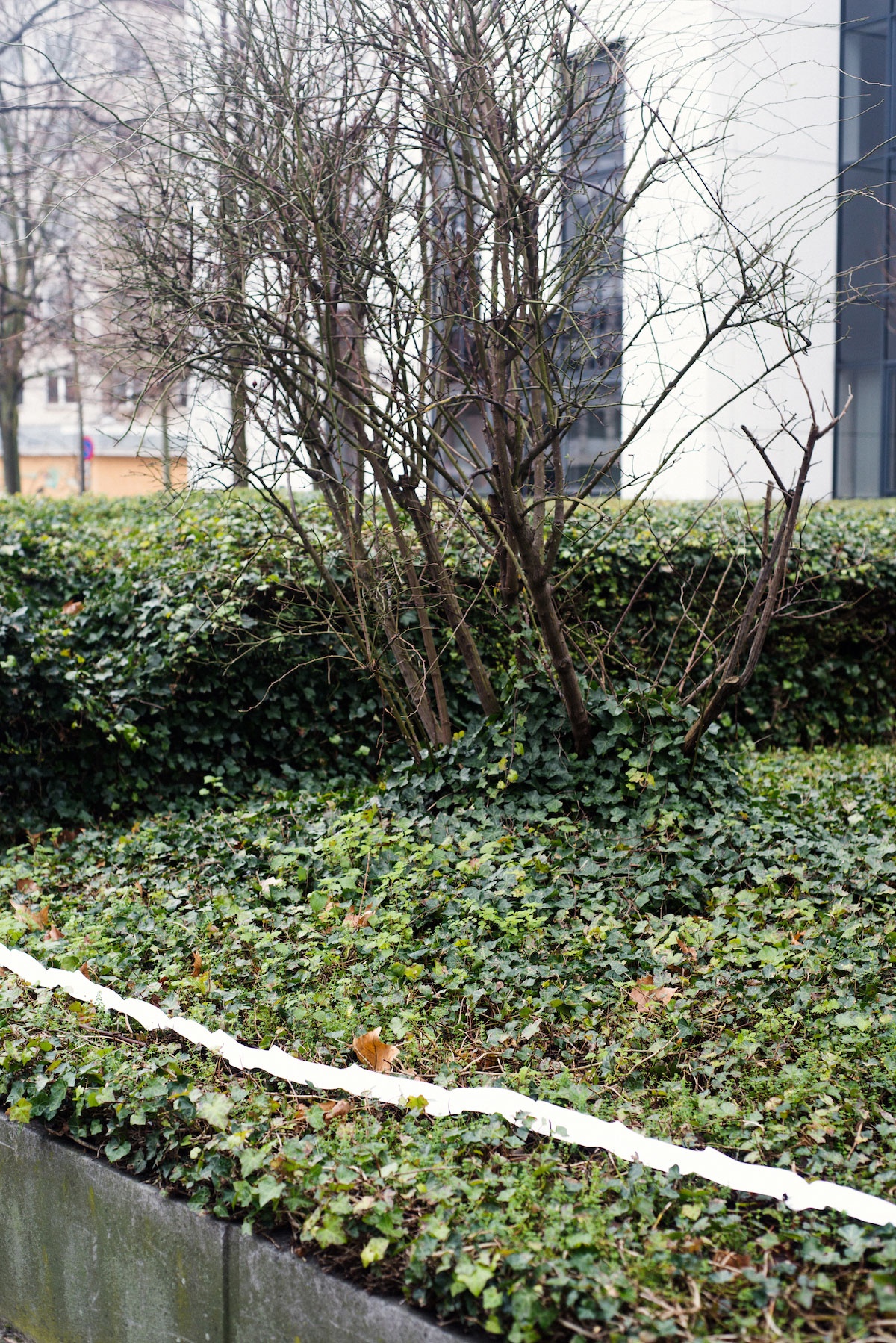 Photo de Nicolas Melemis symbolisant la notion de frontière par la disposition aléatoire, dans l'espace urbain, de bandes réfléchissantes parfois utilisées pour marquer les frontières entre les États